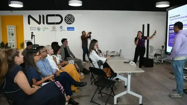 Una expositora presenta su propuesta de matching laboral inclusivo ante un público sentado en el espacio de innovación NIDO