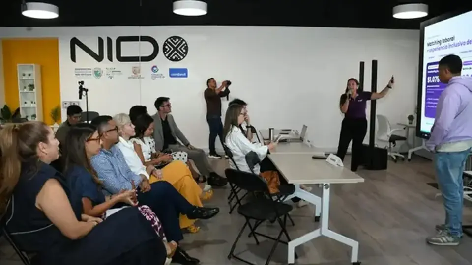 Una expositora presenta su propuesta de matching laboral inclusivo ante un público sentado en el espacio de innovación NIDO