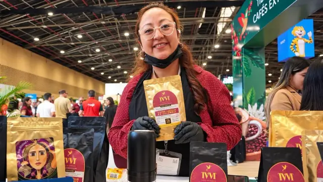 Emprendedora muestra un paquete de café especial de Nariño en su puesto de la feria en Corferias, Bogotá