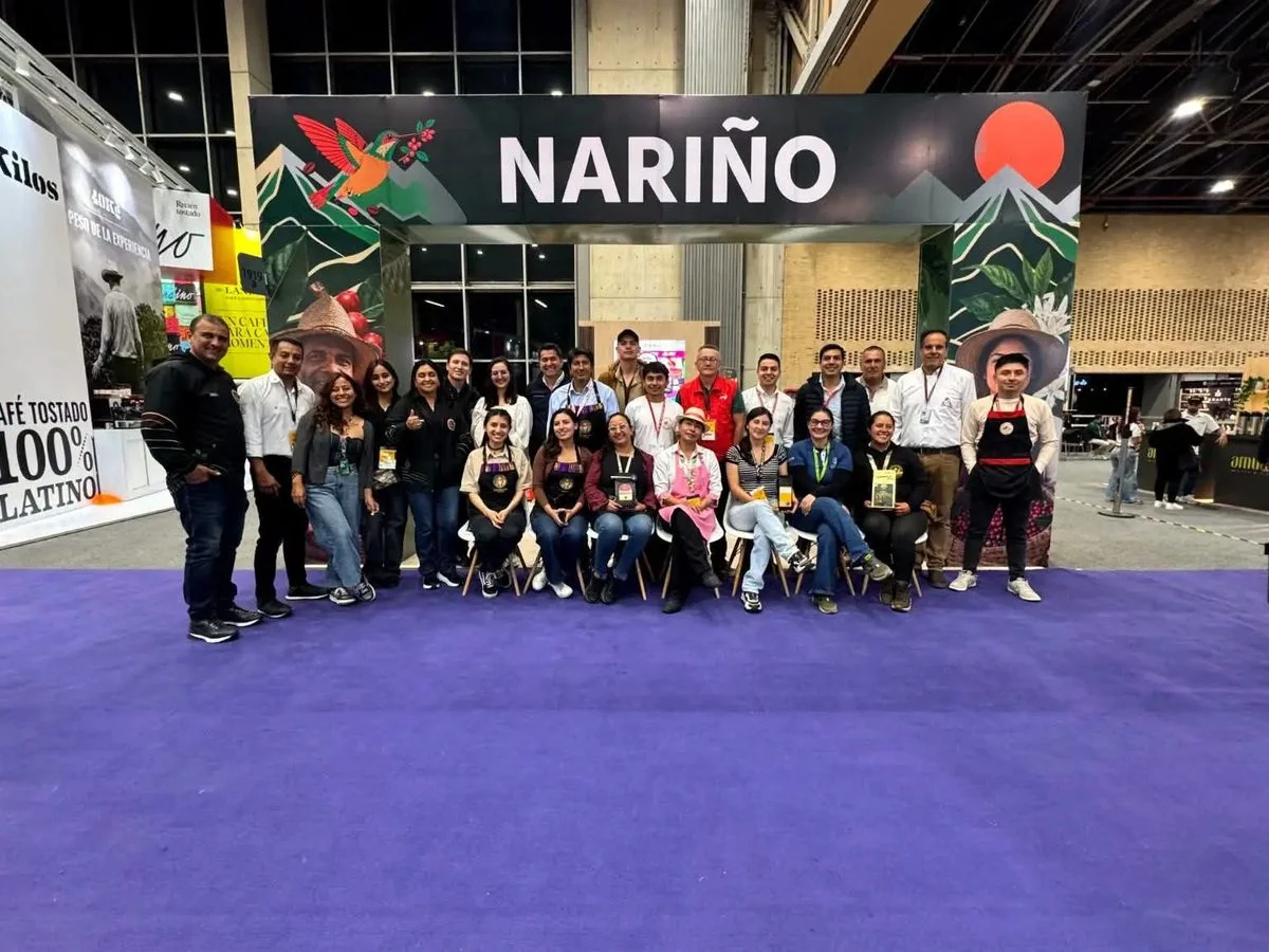 Caficultores y emprendedores posan bajo el arco del pabellón de Nariño en Cafés de Colombia Expo 2026