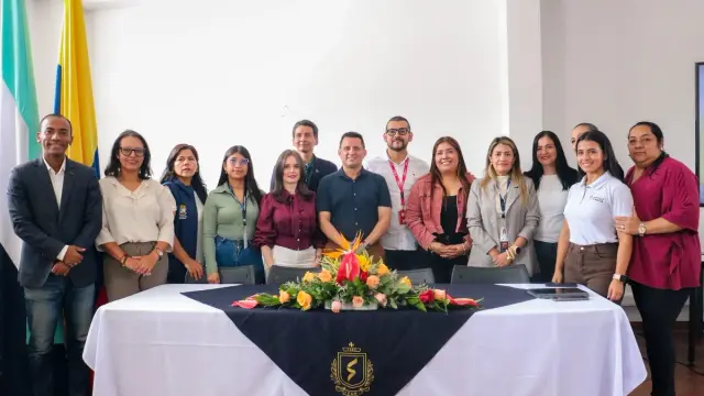 Funcionarios y organizadores posan detrás de una mesa con arreglo floral durante la rueda de prensa de lanzamiento de Cauca Emprende en Popayán
