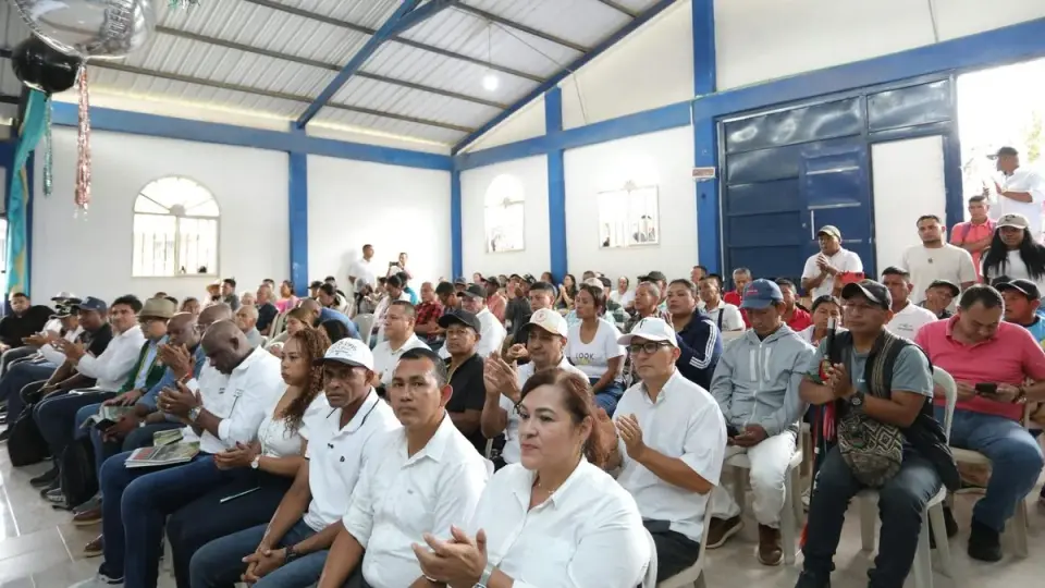 Asistentes sentados en un salón comunal de techo metálico durante el encuentro sobre la pavimentación de la vía San Pedro–La Palomera