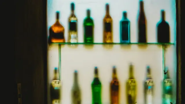 Botellas de licor desenfocadas en un estante iluminado