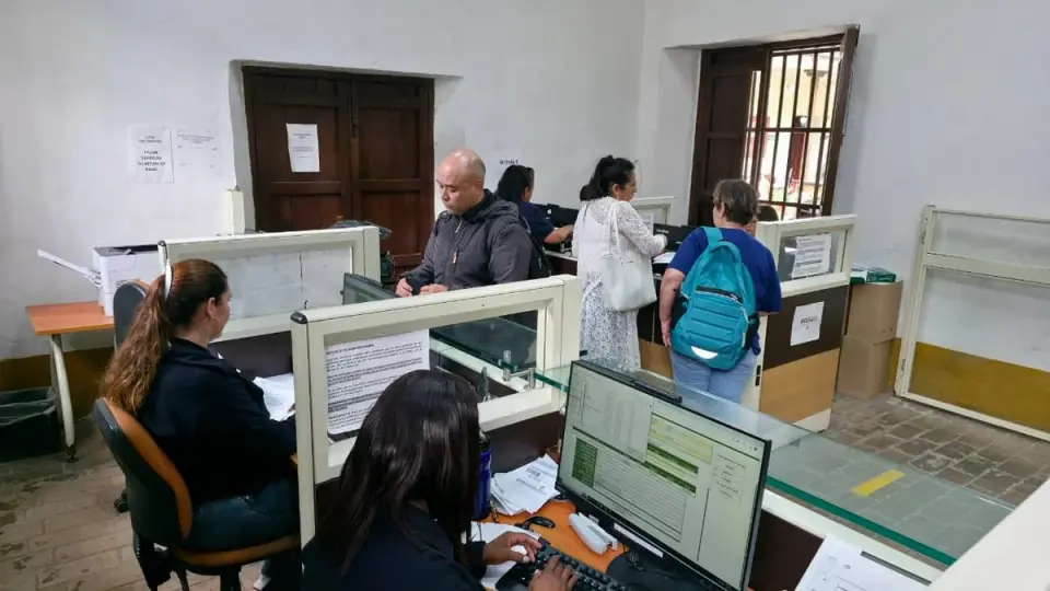 Contribuyentes hacen trámites en las ventanillas de atención de rentas de la Gobernación del Cauca, atendidos por funcionarias en sus computadores