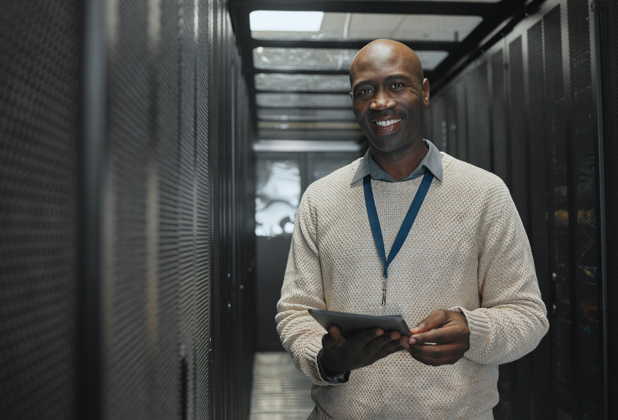 Data center, tablet or black man portrait or technician for system cybersecurity code in server roo